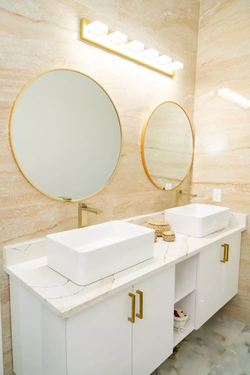 Luxurious bathroom with quartz countertops, top mount porcelain sinks, and polished wall tile