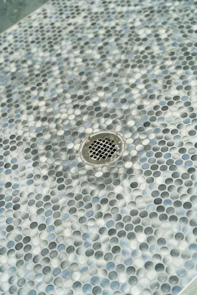Stunning shower floor with penny round tiles in aqua color that is sure to turn heads