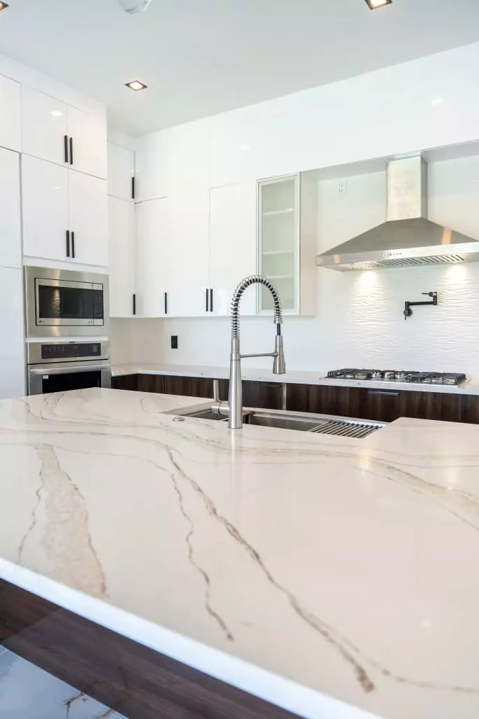 Beautiful kitchen with wave pattern quartz countertops, European style frameless cabinets, and hand made under mount kitchen sink that is sure to impress