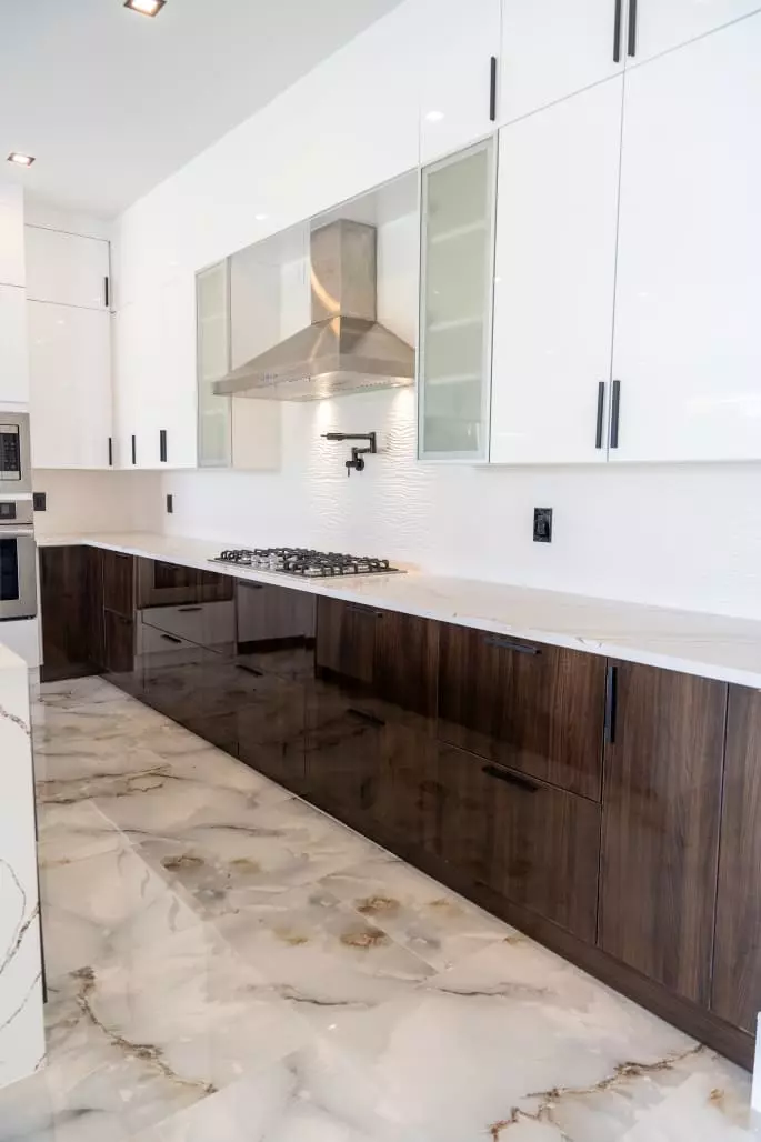 Stunning kitchen with wave pattern quartz countertops, European style frameless cabinets, and contrasting colors that create a modern and stylish space
