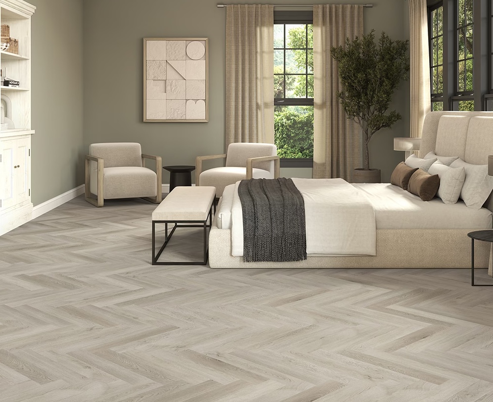 Light oak luxury vinyl plank flooring in herringbone pattern in modern bedroom