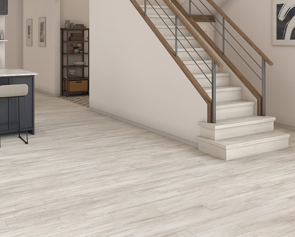 Light wood-look luxury vinyl plank flooring in modern home interior with staircase
